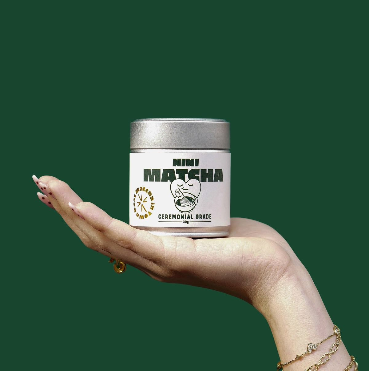 NINI_Ceremonial_Matcha_in_der_Hand_vor_grünem_Hintergrund