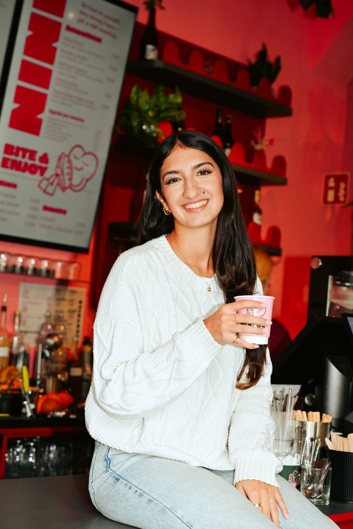 Frau trinkt einen Iced Strawberry Matcha im Café NINI